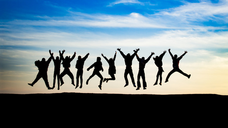 group of young people is jumping on top of the mountain